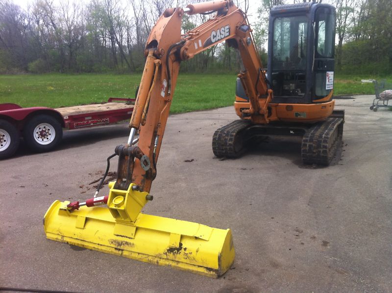 Excavating Solutions machine with a 6-way dozer bucket on a jobsite